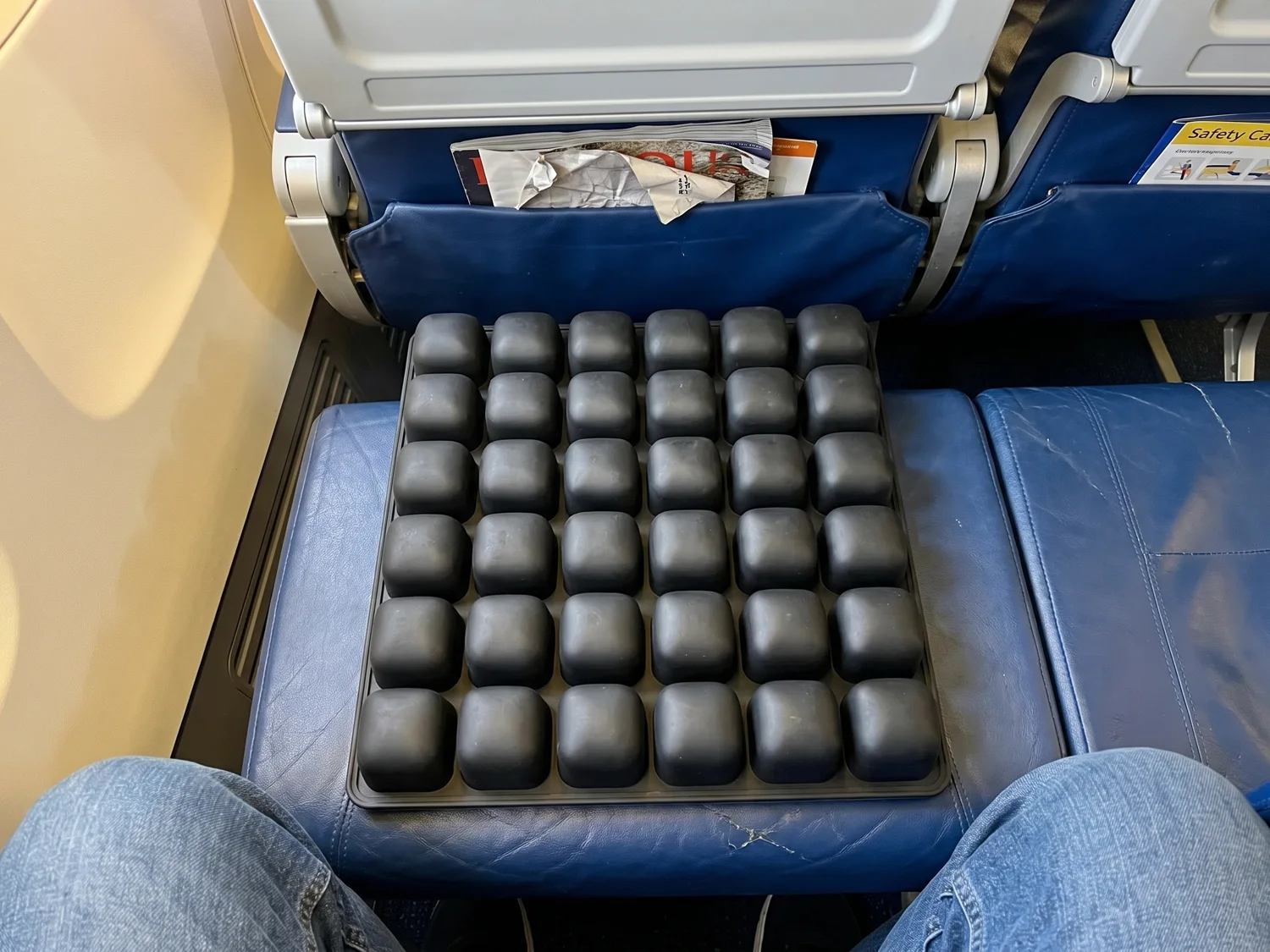 The Ralmutino air-cell cushion placed on an economy seat, seen from the passenger about to sit down